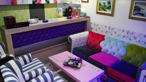 a room with colorful chairs and a table in a salon at Captain's Beach Apartments in Limenas