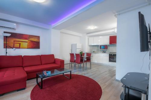 a living room with a red couch and a red rug at Shabbat Apartments in Bucharest
