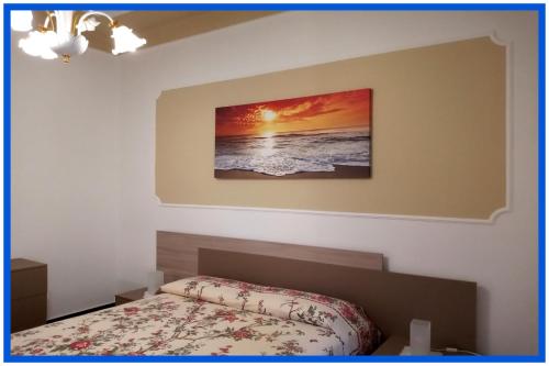 a bedroom with a bed and a picture on the wall at La Casa di Anna a due passi dal mare... e non solo in Vado Ligure