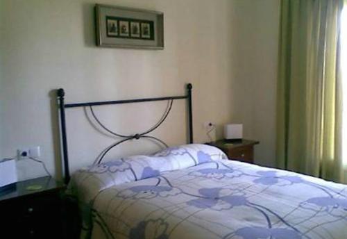 a bedroom with a bed and a picture on the wall at 2 bed apartment with pools and spa in Vera