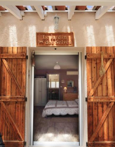 a bedroom with wooden doors and a bed at Le Jardin des Selves in Draguignan