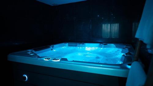 - une baignoire bleue dans une chambre sombre dans l'établissement Love night Marseille jacuzzi, à Le Rove