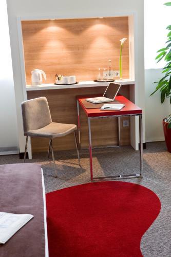 a desk with a laptop and a chair in a room at Mercure Hotel Stuttgart Airport Messe in Stuttgart