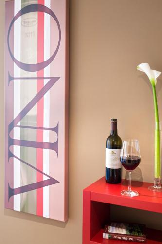 a bottle of wine and a glass on a red table at Mercure Hotel Stuttgart Airport Messe in Stuttgart