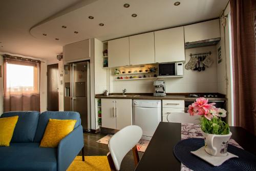 a living room with a blue couch and a kitchen at Amo Bucharest in Bucharest