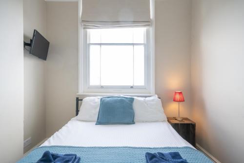 a small bedroom with a bed and a window at The Veteran Hotel & Bar in Ryde