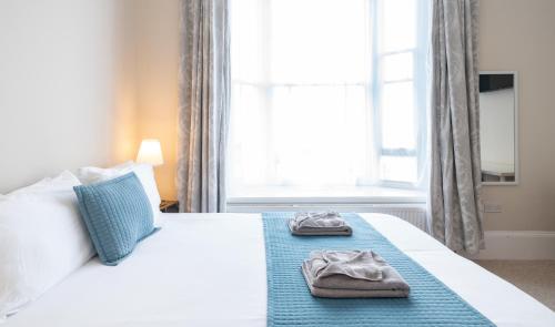 a bedroom with a bed with two slippers on it at The Veteran Hotel & Bar in Ryde