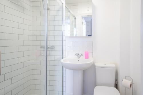 a white bathroom with a sink and a toilet at The Veteran Hotel & Bar in Ryde