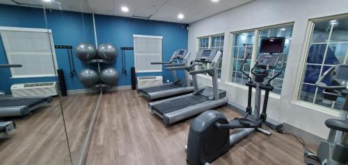 a gym with several tread machines and a television at Holiday Inn Express & Suites Williamsburg by IHG in Williamsburg