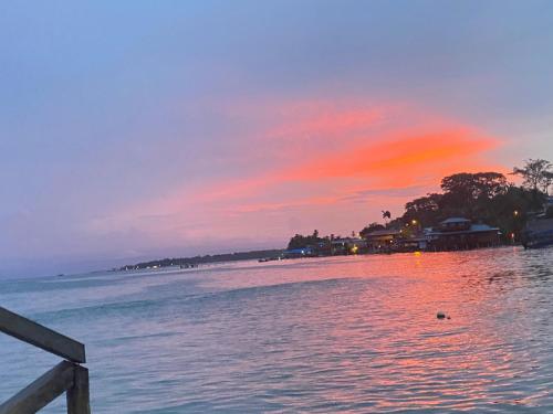 a sunset over a body of water with a pier at Hotel Caribbean View in Bastimentos