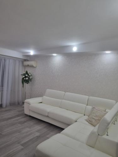 Sala de estar blanca con sofá blanco en White apartament, en Kremenchuk