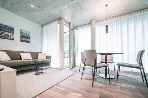 ein Wohnzimmer mit einem Sofa, einem Tisch und Stühlen in der Unterkunft Blackhome Innsbruck City South I contactless check-in in Innsbruck