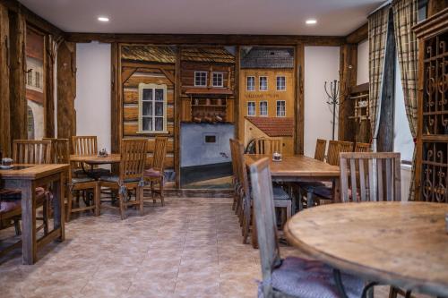 a restaurant with wooden tables and wooden chairs at Penzion Panský dům in Kvilda