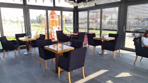 un restaurante con mesas, sillas y ventanas en KASNAR ROOMS, en Zagreb