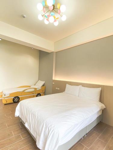 a bedroom with a white bed and a yellow car at Chill鬆口氣-包棟民宿 in Yilan City