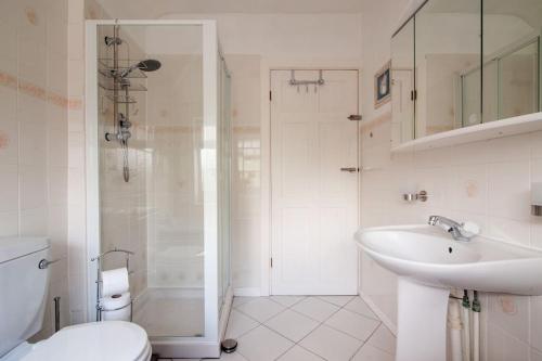 y baño blanco con lavabo y ducha. en Comfortable rooms, en Birmingham