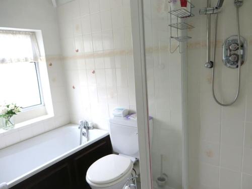 a white bathroom with a toilet and a shower at Comfortable rooms in Birmingham