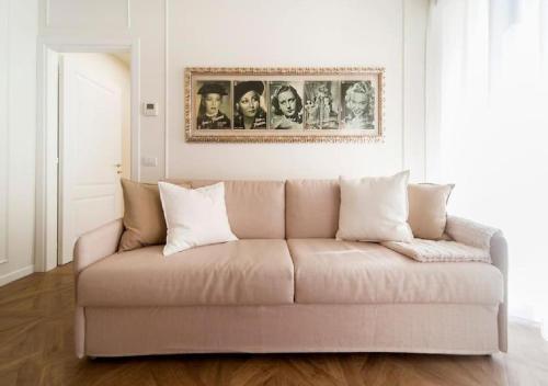 un divano in soggiorno con una foto sul muro di Madonna Montecchi Luxury Suite in Verona a Verona