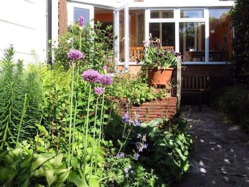 a garden with purple flowers in front of a house at Comfortable rooms in Birmingham