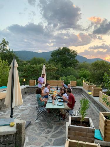 a group of people sitting at a table on a patio at Un je ne sais quoi de Paradis in Les Vans