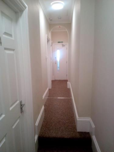 a hallway leading to a door with a light on it at The Veteran Hotel & Bar in Ryde