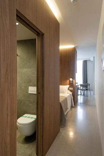 a bathroom with a bed and a toilet in a room at Mon Suites Dau in Valencia
