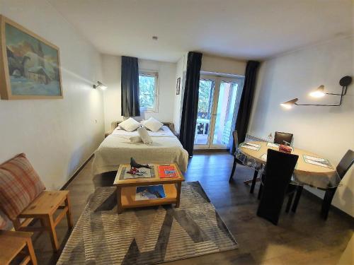 um quarto com uma cama, uma mesa e um sofá em La Riviere Vue Mont Blanc em Chamonix-Mont-Blanc