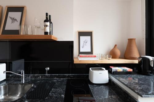 a kitchen with a counter with a toaster and wine glasses at Stay Suites in Cordoba