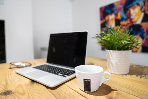 a laptop computer sitting on a wooden table with a coffee cup at The Veteran Hotel & Bar in Ryde