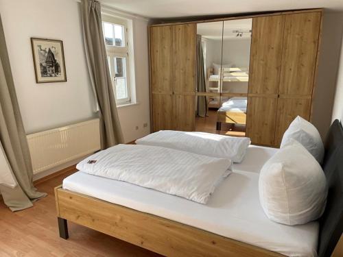 a white bed sitting in a bedroom next to a window at Hotel Goldene Krone in Goslar