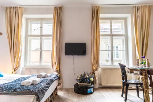 a bedroom with a bed and a table and windows at 2BR- Available in Lockdown & Perfect for Longstays in Vienna