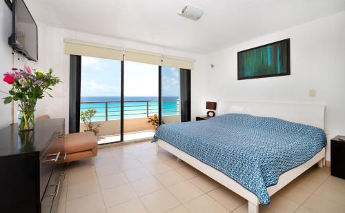 a bedroom with a bed and a view of the ocean at Oceanfront white sand beach condo for families in Cancún