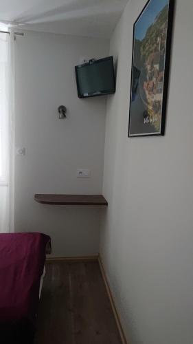 a corner of a room with a tv on the wall at Hôtel de L'Europe in Gramat