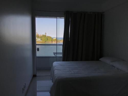 a bedroom with a bed and a window with a view at Vista Mar Premium in Ilhéus