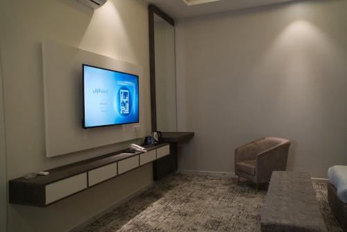 sala de estar con TV de pantalla plana en la pared en فندق راديانس جراند en Abha