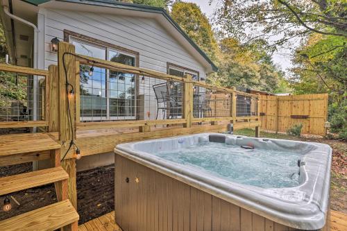 a hot tub on a deck next to a house at Hilltop Hideaway with Scenic Views and Hot Tub! in West Jefferson