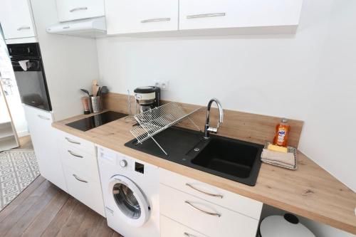 a kitchen with a sink and a washing machine at Napoléon Gare 1 STUDIO Lumineux ByLocly in Pontivy