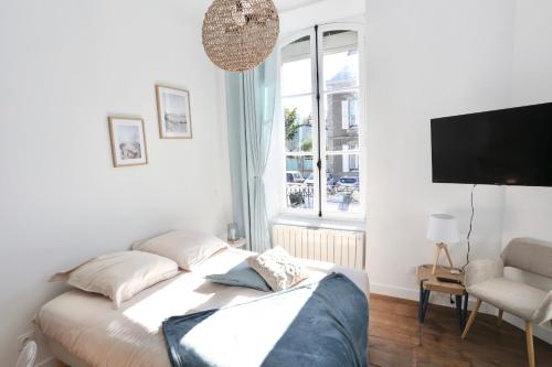 a room with a bed and a tv and a window at Napoléon Gare 1 STUDIO Lumineux ByLocly in Pontivy