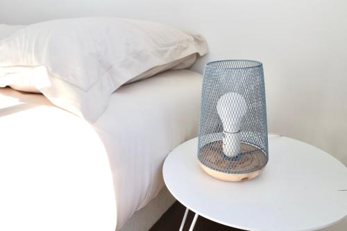 a lamp on a table next to a bed at Napoléon Gare 1 STUDIO Lumineux ByLocly in Pontivy