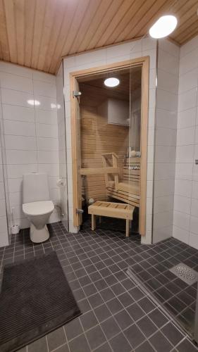 a bathroom with a toilet and a table in a room at First Class-Annankatu in Pori