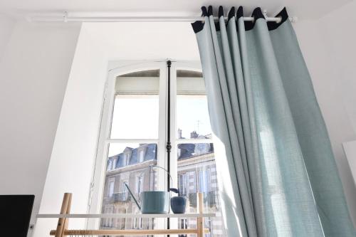 a window with curtains in a living room at Napoléon Gare 1 STUDIO Lumineux ByLocly in Pontivy