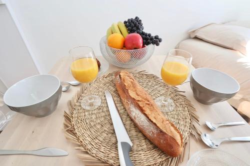 a table with a plate of bread and a bowl of fruit at Napoléon Gare 1 STUDIO Lumineux ByLocly in Pontivy