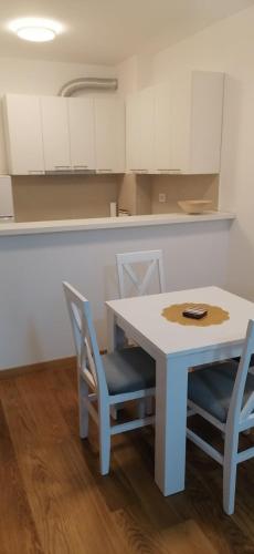 a kitchen with a table and chairs and white cabinets at MoonZe Gate in Belgrade