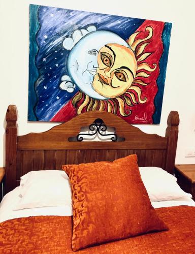 a painting on the wall above a bed at El Lagar de los Abuelos in Arcos de la Frontera