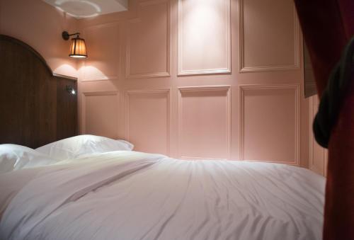 a bedroom with a white bed with a window at Mimi's Hotel Soho in London