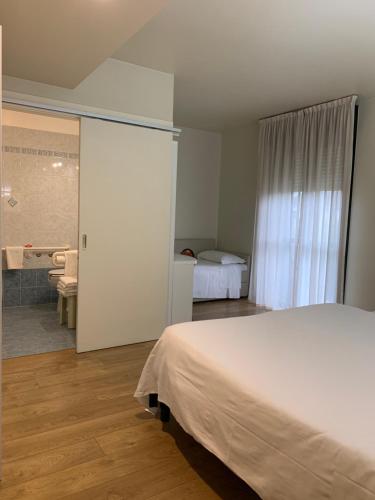 a bedroom with a bed and a bathroom with a shower at Hotel Parigi 2 & Spa in Dalmine