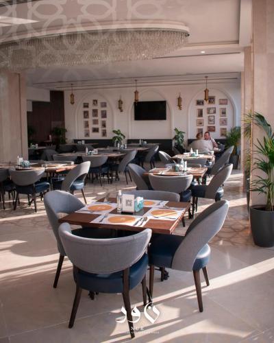 a restaurant with tables and chairs in a room at Andalus Hotel in Baghdad