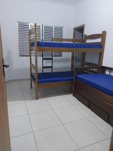 a room with two bunk beds and a table at Sobrado com vista ao mar in São Vicente