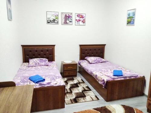 2 letti posti uno accanto all'altro in una camera da letto di Chinara Guest House Airport a Tashkent
