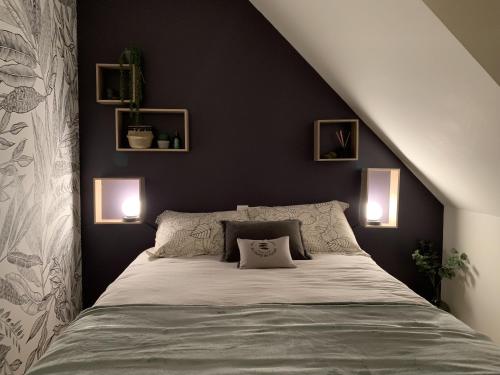 una camera da letto con un letto con due luci sul muro di L'escale 551, gîte Santec à 250m de la plage a Santec